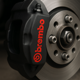 Brembo brake caliper on a car wheel with a dark background