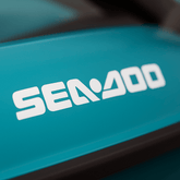 Close-up of a Sea-Doo logo on a teal background