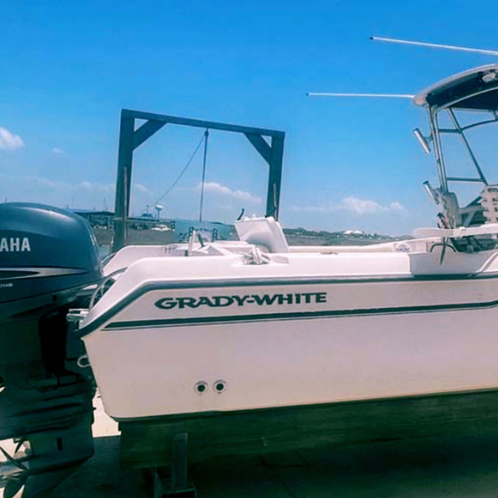 White Grady-White boat with Yamaha outboard motor on a dock under a clear blue sky.