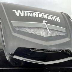 Winnebago logo on the front of a large vehicle, likely an RV.