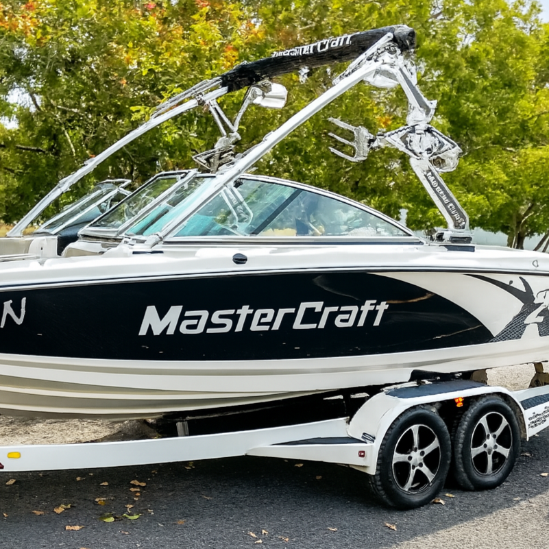 MasterCraft boat on a trailer with trees in the background