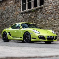 Lime green Porsche sports car parked in front of a stone building