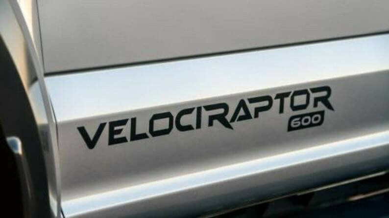 Close-up of a 'Velociraptor 600' decal on a vehicle's side panel.