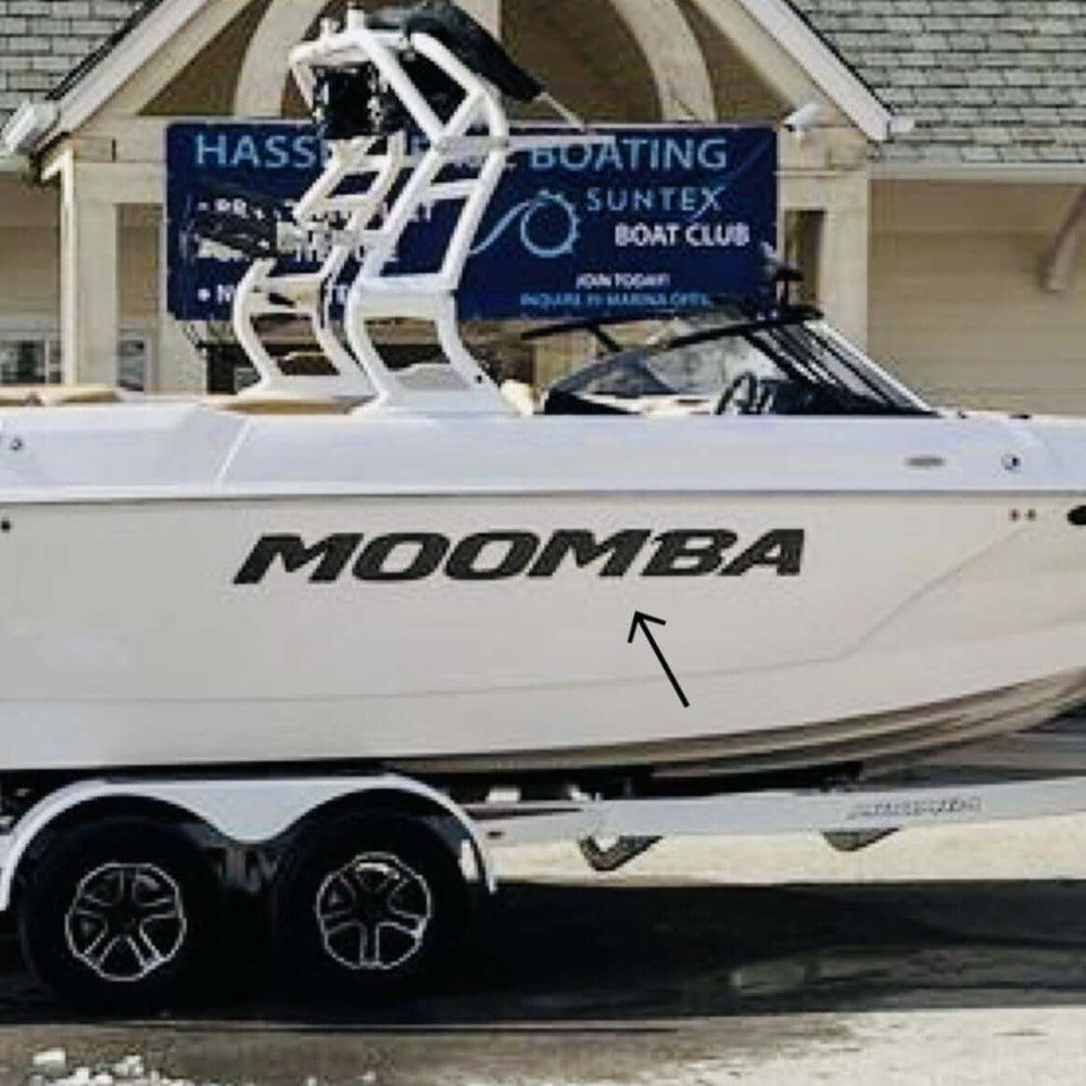 White Moomba boat on a trailer in front of a building with a sign for Hassett Boating Suntex Boat Club.