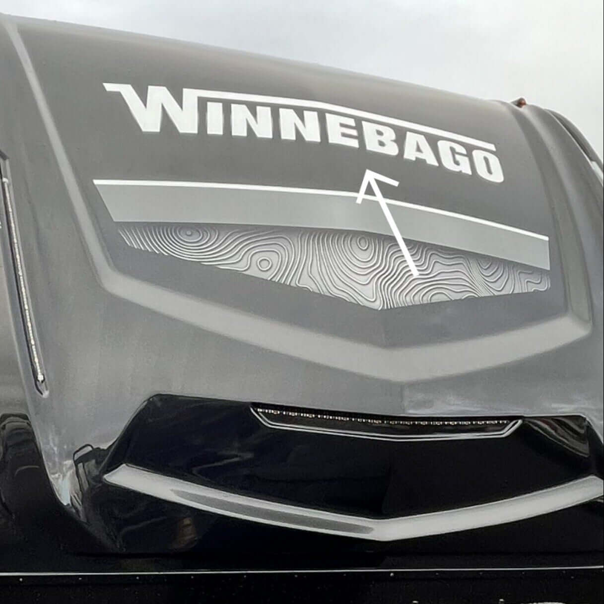 Winnebago logo on the front of a large vehicle, likely an RV.