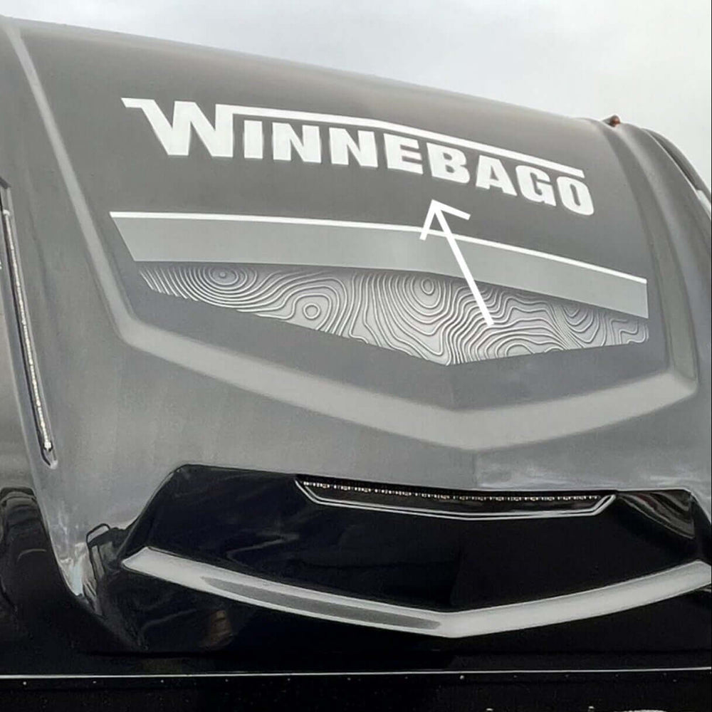 Winnebago logo on the front of a large vehicle, likely an RV.